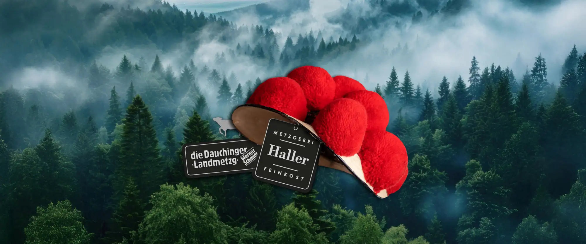 Roter, flauschiger Pompon-Hut mit braitem Rand und schwarzen Etiketten, auf denen ’die dauchinger landmetzg’ und ’haller feinkost.’ steht.